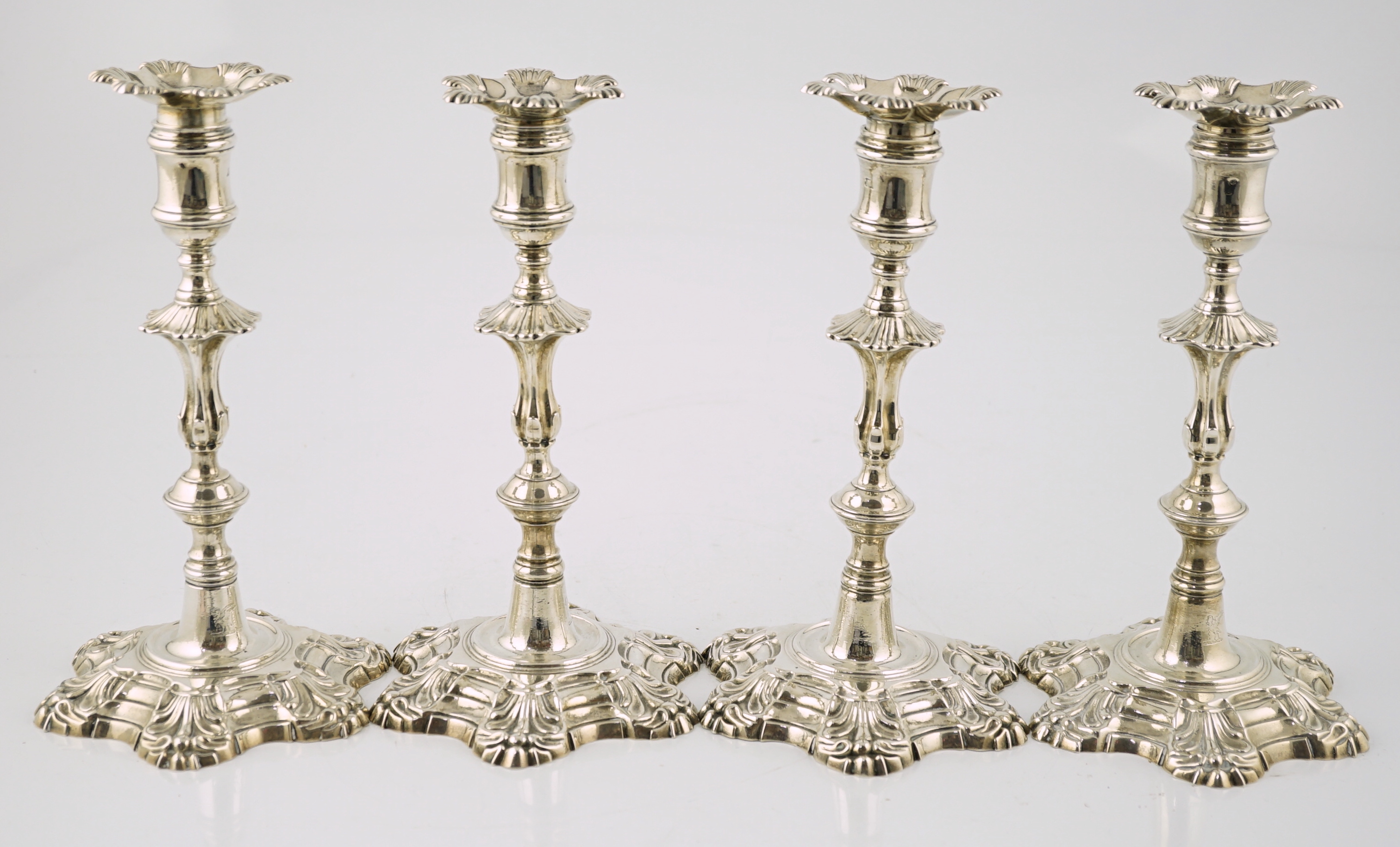 A set of four George II cast silver table candlesticks, by John Cafe